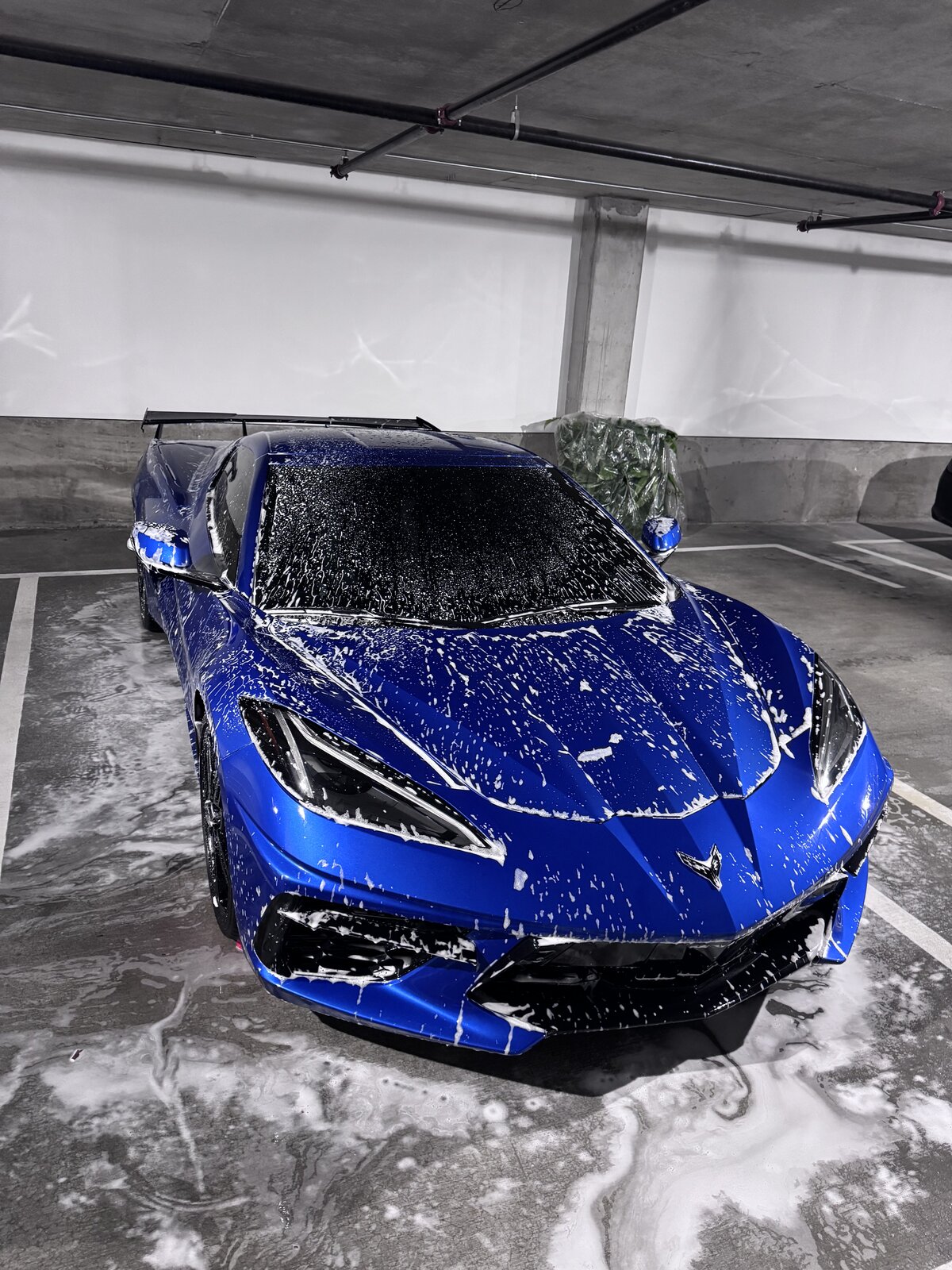 Blue Chevrolet Corvette covered in foam during an Apex foam hand wash